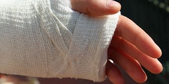 Zum Ruhigstellen wird der Arm mit einem Verband versehen.